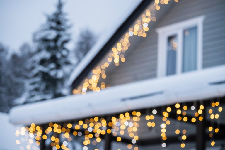 Beautiful home with festive Christmas lights in snowy setting