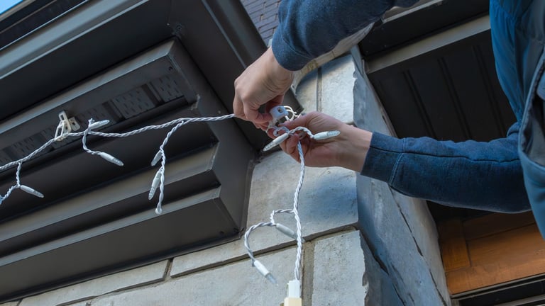 Installing decorative lights on building exterior for festive celebrations